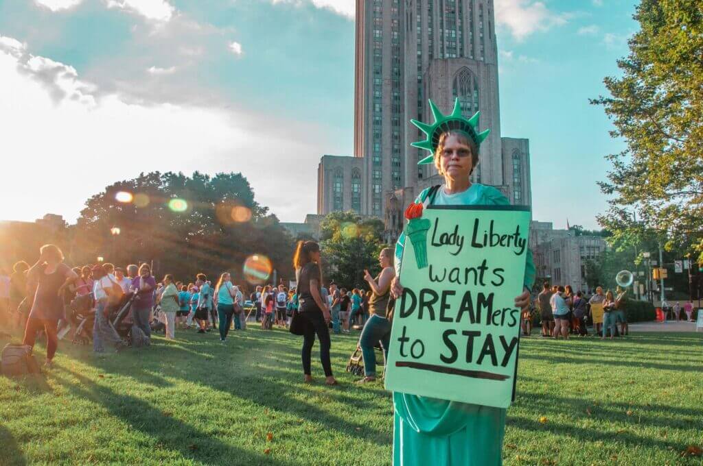 Mujer sosteniendo cartel que dice Lady Liberty wants dreamers to stay